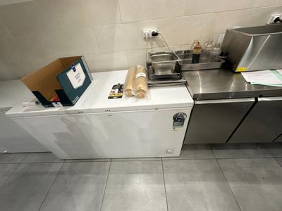une image d'une cuisine avec un évier et un réfrigérateur