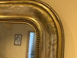 a mirror hanging on the wall with a cat in the reflection