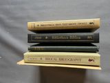trois livres sont empilés sur une table