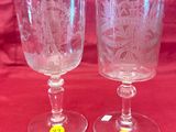 two wine glasses sitting on a red cloth