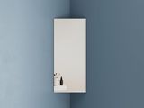 un miroir sur le mur au-dessus d'un lavabo dans une salle de bains