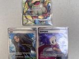 three pokemon cards are sitting on top of each other on a table