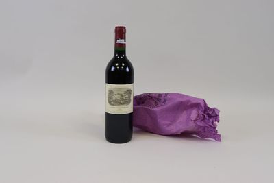 une bouteille de vin posée à côté d'un sac violet