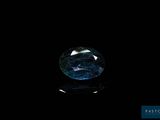 a close up of a blue diamond on a black surface