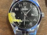 une montre posée sur une table à côté d'une autre montre