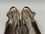 une paire de chaussures Chanel posées sur une surface blanche