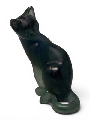 a black cat statue sitting on a white surface