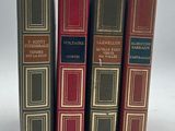 quatre livres sont alignés sur une surface blanche