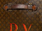 a close up of a brown suitcase with a d v on it
