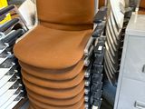 a lot of chairs stacked on top of each other in a warehouse