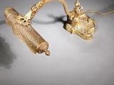 pair of gold - plated lamps on a white surface with a black background