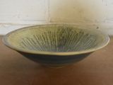 a green and black bowl sitting on a table