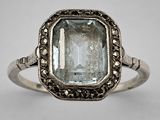 a close up of a ring with an aquamarine stone in it