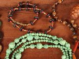 many different colored beads on a wooden table