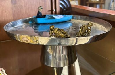 une assiette en argent sur laquelle est représenté un bateau bleu