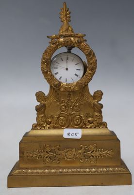 a gold clock sitting on top of a table