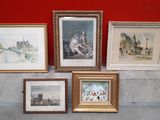 four framed pictures on a ledge with a red wall in the background