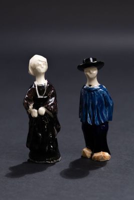 deux figurines d'un homme et d'une femme debout l'un à côté de l'autre