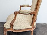 an old fashioned chair with a wooden frame and upholstered seat