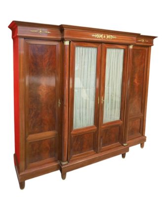 une grande armoire en bois munie d'une porte vitrée
