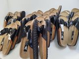 many pairs of sandals that are lined up on a shelf