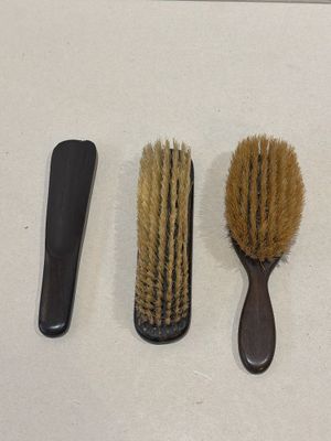 trois brosses et un peigne posés sur une table