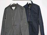 two jackets hanging on a clothes rack in a white room