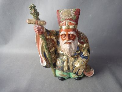 une figurine représentant un homme tenant une épée et un oiseau