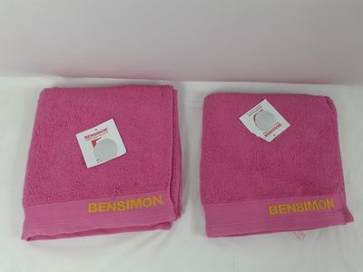 deux serviettes roses posées l'une à côté de l'autre sur un lit