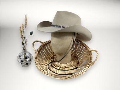 un chapeau et un crâne posés sur une table, à côté d'un vase