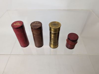 several different sized coins are sitting in a clear display case
