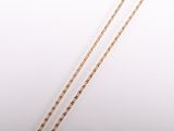 a close up of a necklace with a gold chain on a white background