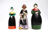 three ceramic figurines of women in different colors and sizes
