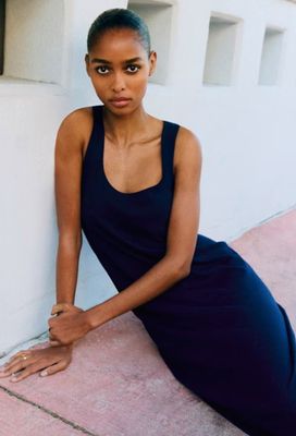 a woman that is sitting on the ground posing for a picture