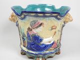 un vase bleu et jaune sur lequel est assise une femme