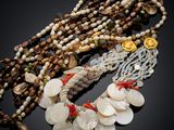 several necklaces with shells and beads on a black surface