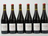six bouteilles de vin sont alignées sur une table