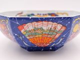 a blue bowl with a design on it on a white surface