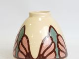 a white vase with a pink and green design on it