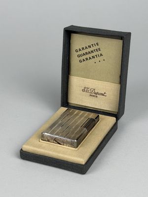 DUPONT. Briquet en métal argenté à décor guilloché et strié.