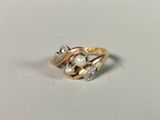 a gold ring with a pearl and diamonds on it