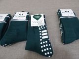 three pairs of green socks with white polka dots on them