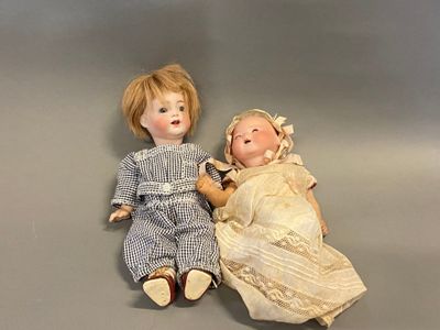 two dolls sitting next to each other on a table