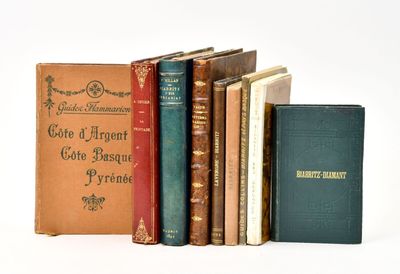 several old books are lined up on a white surface
