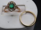 a gold ring with a green stone in it and a gold ring with a green stone in it