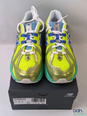 a pair of yellow and blue running shoes on top of a box