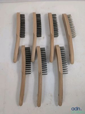 cinq peignes en bois avec des poils noirs sur un fond blanc