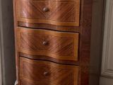 a small chest of drawers in the corner of a room