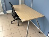 a desk and chair in a room with a blue wall