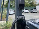 une voiture noire branchée sur une borne de recharge électrique
